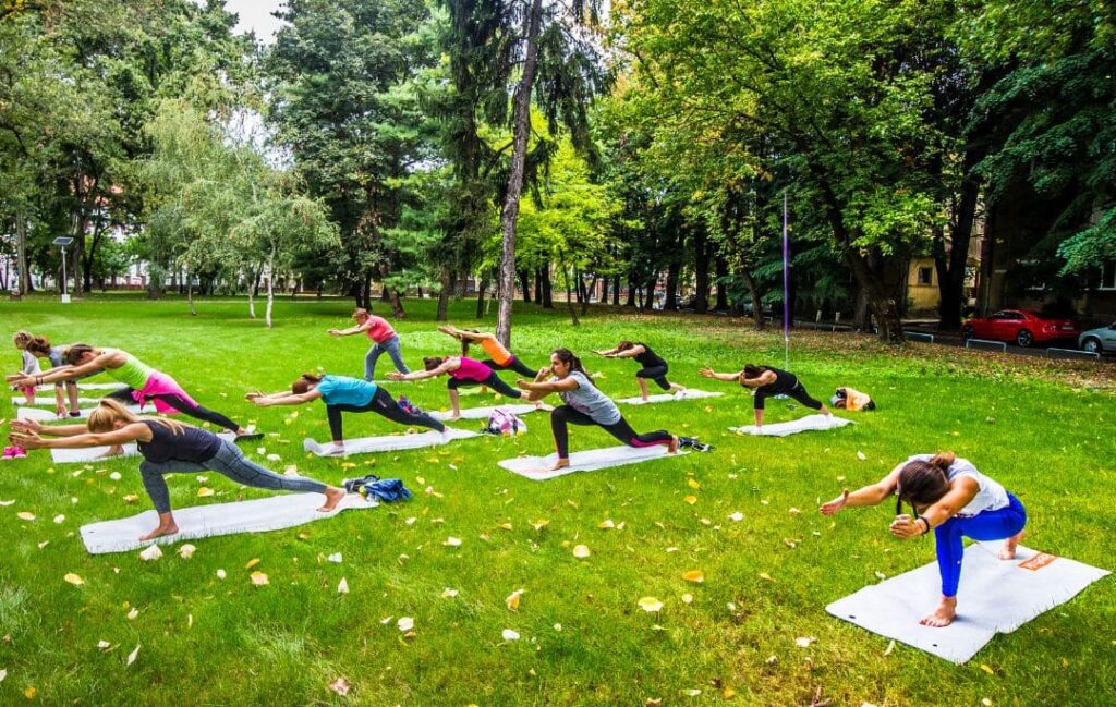 Ejercicio en casa. Aparecen un grupo de mujeres estirando en un bosque.
