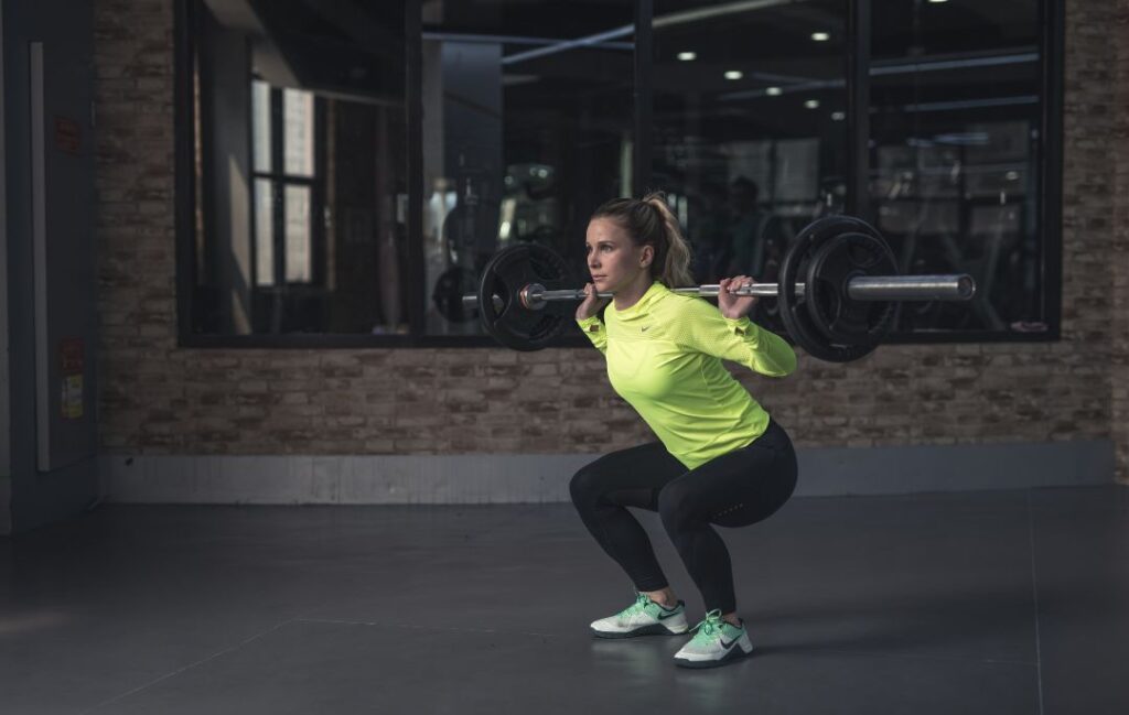 mujer haciendo sentadillas en el gimnasio